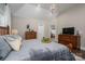 Spacious main bedroom featuring a wooden bed frame, vaulted ceilings, and access to the ensuite bathroom at 7988 Golf Course N Dr, Denver, NC 28037