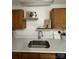 Clean kitchen area features stainless steel sink, neutral countertops, and decorative shelving, with natural light and simple decor at 8322 Summerglen Cir, Charlotte, NC 28227