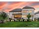 Stunning backyard view of the brick home with manicured lawn and mature landscaping at twilight at 920 Terramore Dr, Waxhaw, NC 28173