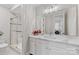 Bright bathroom featuring a sliding glass shower, white marble counters, and a large mirror at 920 Terramore Dr, Waxhaw, NC 28173