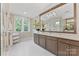 Bright bathroom featuring a dual vanity, large framed mirror, white marble floors, and windows at 920 Terramore Dr, Waxhaw, NC 28173