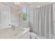 Bright bathroom featuring a white vanity with marble countertop and a shower/tub with patterned curtain at 920 Terramore Dr, Waxhaw, NC 28173