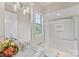 Bright bathroom featuring a shower with glass doors, marble countertops, and a large window at 920 Terramore Dr, Waxhaw, NC 28173