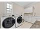 Well-lit laundry room with modern washer and dryer, white cabinetry and patterned tile floor at 920 Terramore Dr, Waxhaw, NC 28173