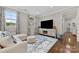 Cozy living room featuring hardwood floors, a comfortable sofa, and a large television at 920 Terramore Dr, Waxhaw, NC 28173