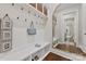 Bright mudroom with storage shelves, bench, coat hooks, wood floors, and an ornate mirror at 920 Terramore Dr, Waxhaw, NC 28173