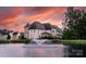Picturesque view of the home across a pond with a fountain at sunset at 920 Terramore Dr, Waxhaw, NC 28173