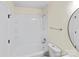 A clean bathroom with a shower-tub combo, wall shelves, and modern fixtures at 10016 Heathergate Ln, Mint Hill, NC 28227
