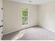 Bedroom featuring neutral carpet and a large window with a view of the greenery at 10016 Heathergate Ln, Mint Hill, NC 28227