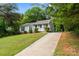 Inviting single-story home with well-manicured lawn and a long driveway, set amongst mature trees at 10016 Heathergate Ln, Mint Hill, NC 28227