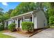 Angled exterior of home with black shutters and brick accents, with a well-maintained lawn and partial shade at 10016 Heathergate Ln, Mint Hill, NC 28227