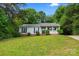 Attractive one-story home with a verdant front yard, complemented by black shutters and lush greenery at 10016 Heathergate Ln, Mint Hill, NC 28227