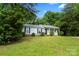 Front yard view of a cozy home with black shutters, enhanced by the surrounding lush landscaping at 10016 Heathergate Ln, Mint Hill, NC 28227