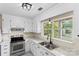 Bright kitchen with white cabinetry, marble countertops, stainless steel appliances, and a view from the window at 10016 Heathergate Ln, Mint Hill, NC 28227