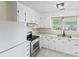 Bright kitchen with white cabinets, stainless steel oven, and a white refrigerator for a clean aesthetic at 10016 Heathergate Ln, Mint Hill, NC 28227