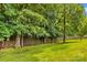 The backyard offers a lovely lawn bordered by a wooden fence and lush green trees for privacy and shade at 103 Prestwick Ct, Salisbury, NC 28146