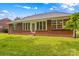Backyard featuring a brick house, green lawn, and blue sky at 103 Prestwick Ct, Salisbury, NC 28146