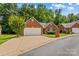 Charming brick home featuring an attached two car garage, manicured lawn, and mature landscaping at 103 Prestwick Ct, Salisbury, NC 28146