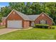Charming one-story brick home with an attached garage, manicured lawn, and lush landscaping at 103 Prestwick Ct, Salisbury, NC 28146
