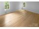 Bright, empty bedroom with hardwood floors, white walls and trim, and windows with lots of natural light at 10931 Osprey Dr, Charlotte, NC 28226