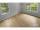 Bedroom with hardwood floors, white walls, white trim, and plenty of natural light at 10931 Osprey Dr, Charlotte, NC 28226