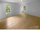 Bright bedroom with hardwood floors features two windows for natural light and airflow at 10931 Osprey Dr, Charlotte, NC 28226