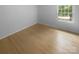 Bright, empty bedroom with hardwood floors, white walls and trim, and a single window at 10931 Osprey Dr, Charlotte, NC 28226