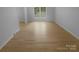 Bright, empty bedroom with hardwood floors, white walls, trim and plenty of natural light through a large window at 10931 Osprey Dr, Charlotte, NC 28226