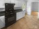 Updated kitchen features black appliances, white cabinets, a pantry, and tile floors at 10931 Osprey Dr, Charlotte, NC 28226