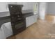 Updated kitchen with black appliances, white cabinets and drawers, and tile flooring at 10931 Osprey Dr, Charlotte, NC 28226