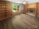 Cozy living room with hardwood floors, built-in bookshelves, a brick fireplace, and a large window at 10931 Osprey Dr, Charlotte, NC 28226