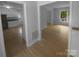 Open-concept living room with hardwood floors, neutral paint, and bright sunlight leads to the kitchen at 10931 Osprey Dr, Charlotte, NC 28226