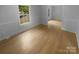 Well-lit living room with light-colored hardwood floors, and bright white trim and walls at 10931 Osprey Dr, Charlotte, NC 28226