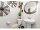 Stylish half bathroom with patterned wall decor, a pedestal sink, neutral color scheme, and modern fixtures at 1117 Laurel Woods Dr, Gastonia, NC 28052