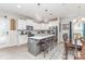 Modern kitchen features an island with bar stool seating, stainless steel appliances, and white cabinetry at 1117 Laurel Woods Dr, Gastonia, NC 28052