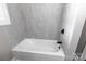 Bathroom features a white tub with gray marble-like tile at 1210 Cloninger Ave, Gastonia, NC 28052