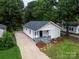 Charming house with a landscaped front yard, gravel driveway and gray painted porch at 1210 Cloninger Ave, Gastonia, NC 28052