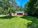 Charming single-story brick home with a lush green lawn and mature trees at 12143 Asbury Chapel Rd, Huntersville, NC 28078