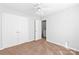 Clean bedroom with neutral carpet, white trim, a ceiling fan, and a double-door closet at 12452 Stratfield Place Cir, Pineville, NC 28134