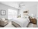 Bright bedroom features a ceiling fan, neutral walls, large window, and stylish furnishings at 12452 Stratfield Place Cir, Pineville, NC 28134