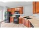 Well-lit kitchen featuring wooden cabinetry, black appliances, and light colored flooring at 12452 Stratfield Place Cir, Pineville, NC 28134