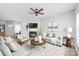 Spacious living room with a fireplace, ceiling fan, modern furnishings, and neutral decor at 12452 Stratfield Place Cir, Pineville, NC 28134