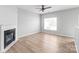 Cozy living room featuring a fireplace, fan, and modern flooring with ample natural light at 12452 Stratfield Place Cir, Pineville, NC 28134