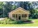 Charming home with a welcoming front porch, landscaped yard, and a backdrop of lush trees at 13414 Central Ave, Huntersville, NC 28078