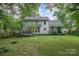 Charming backyard with a deck and a well-manicured lawn, surrounded by mature trees and greenery at 13416 Kintyre Ct, Matthews, NC 28105