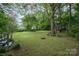 Expansive backyard featuring lush greenery, mature trees, and play equipment at 13416 Kintyre Ct, Matthews, NC 28105