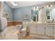 Bathroom with dual vanity, skylight, tub, and separate toilet at 13416 Kintyre Ct, Matthews, NC 28105