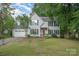 Charming two-story home with a well-manicured lawn, blue shutters, and a welcoming red front door at 13416 Kintyre Ct, Matthews, NC 28105