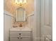 Elegant powder room featuring a unique mirror and decorative gold faucet at 13416 Kintyre Ct, Matthews, NC 28105