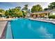 Community pool and clubhouse with ample seating, umbrellas, and lush landscaping at 14529 Waterside Dr, Charlotte, NC 28278